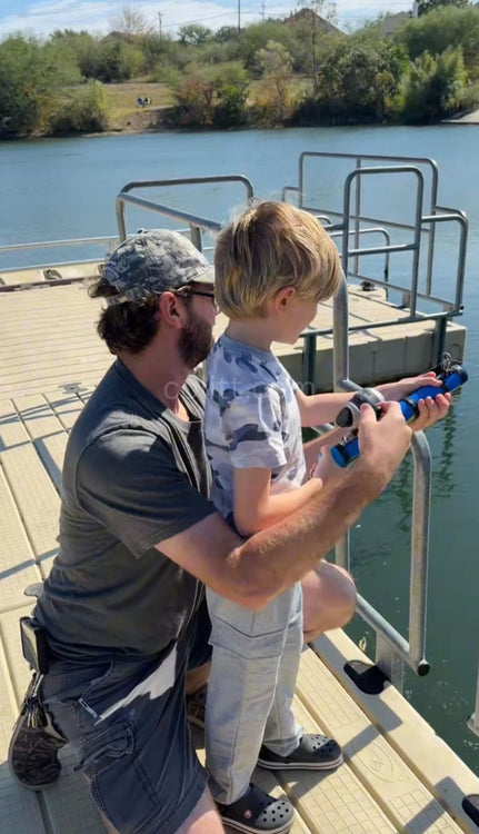 Parent and child fishing together at the water's edge
