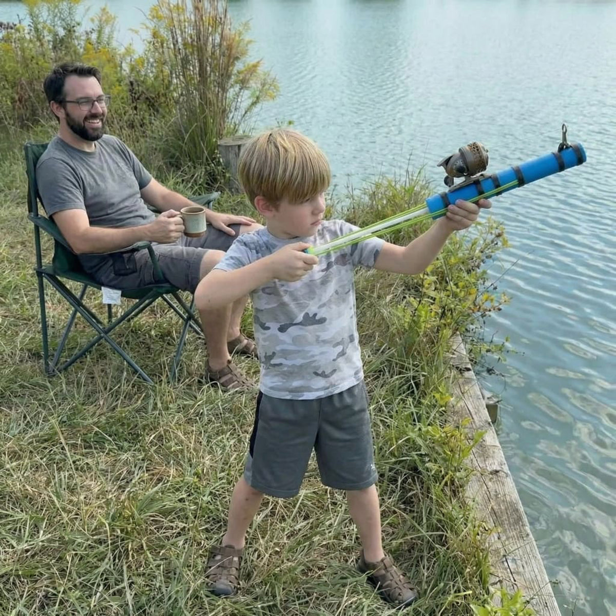 Child using the Catapult fishing rod by a lake